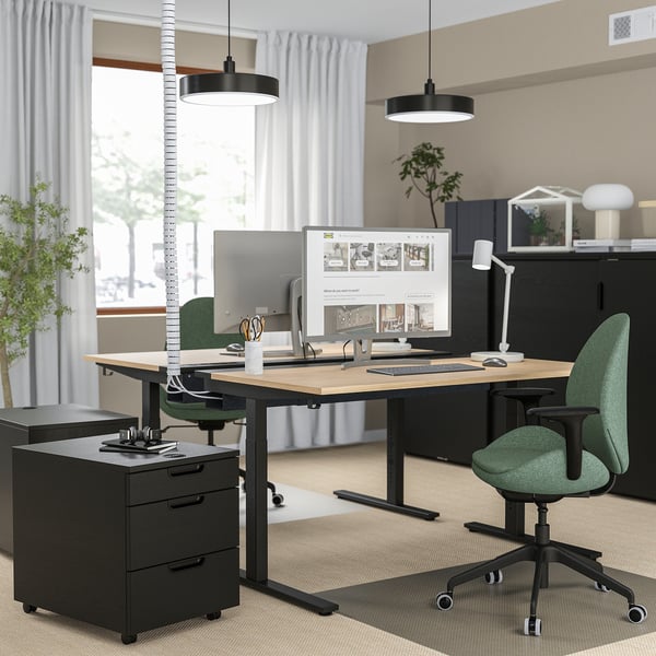 Modern office with MITTZON desk, green chair, monitors, plants, minimalist decor.