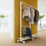 MITTZON garment rack in white holds jackets & denim, against yellow wall, 2 tiers.