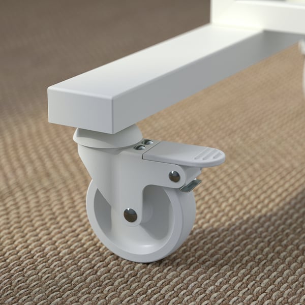 Close-up of a sturdy, white office castor with lock and spherical wheel on beige carpet.
