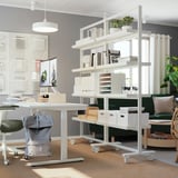 Office with MITTZON shelving, books, plants, desk, computer, chair, backpack.