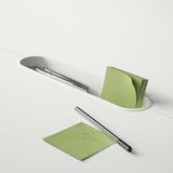 Desk with pen holder and sticky notes.