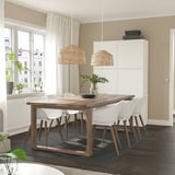 Modern dining area with MÖRBYLÅNGA table, chairs, pendant lights, and storage unit. Natural light through large windows.