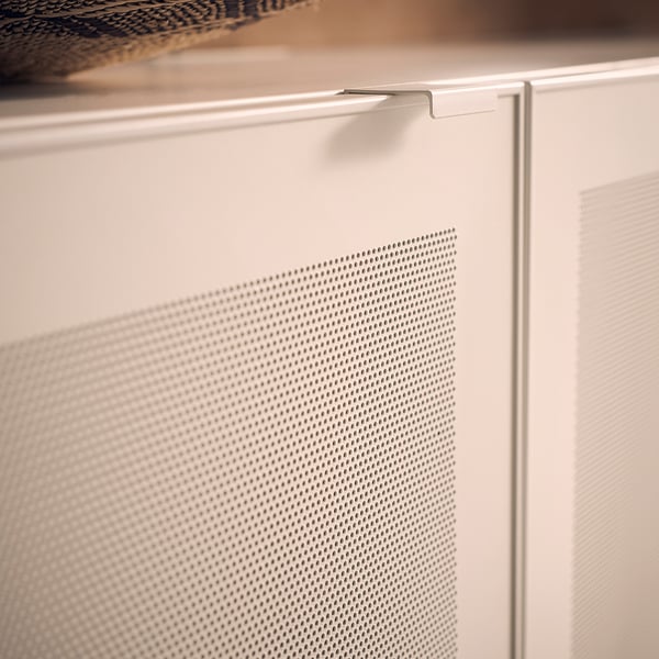 Close-up of a white MÖRTVIKEN mesh cabinet door. Modern metal design with small hole patterns.