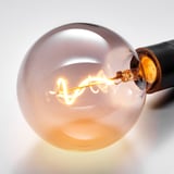 Led bulb with spiral filament inside frosted glass, lit, warm glow.
