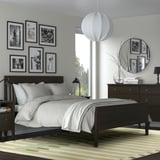 Modern bedroom with rug, wooden bed, globe lamp, photo wall.