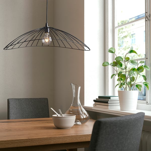 Cozy dining area with MOTSJÖ lamp, plant, and vase.