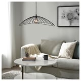 Modern living room with elliptical MOTSJÖ lamp over coffee table with decor.