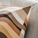 Striped cushion cover with warm tones, showing quality stitching and fabric texture.