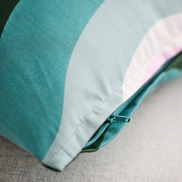 Close-up of teal cushion with white stripes and zipper, showcasing quality fabric and stitching.