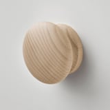 Natural wood knobs, smooth finish, round shape, light color, precise craftsmanship, mounted on wall.