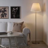 Cozy living room with MYRHULT floor lamp, sofa, and botanical prints.