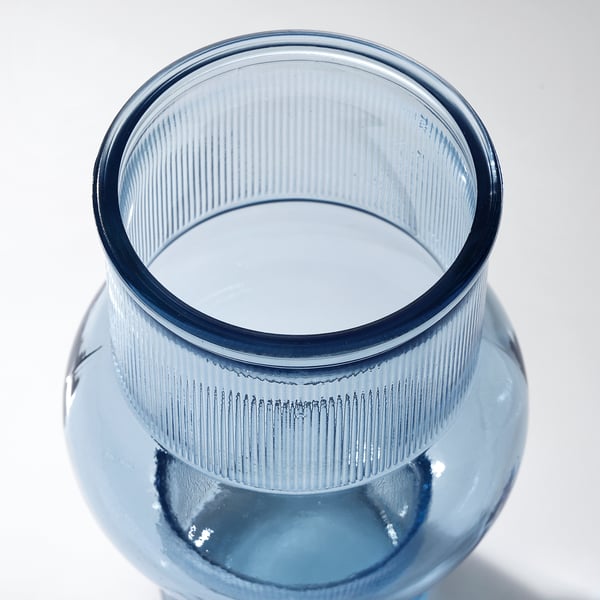Glass vase, recycled with unique bubbled texture, vibrant blue hue. Seen from above, smooth interior, clean lines.