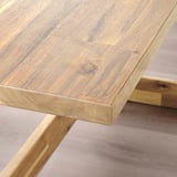 Close-up of a smooth, polished, light-colored wooden table with visible grain patterns.