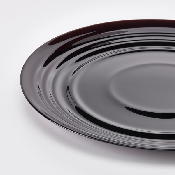 Round plate with glossy, rippled pattern. Tempered glass, elegant feel, modern design.