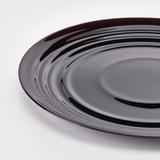 Round plate with glossy, rippled pattern. Tempered glass, elegant feel, modern design.