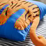 Diffuse, plush tiger pillow with blue accent, soft, inviting, recycled materials, cozy.