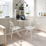 Wall-mounted drop leaf table with 2 folding chairs, perfect for small spaces. Holds laptop & drink, with storage shelves. Chairs fold & store neatly.