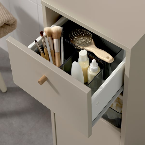 Open bathroom cabinet shows toiletries and makeup brushes, indicating storage solution.