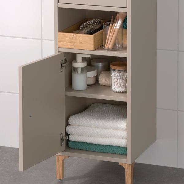 Cabinet with open and hidden storage, ideal for small spaces. Shelves hold towels and bathroom essentials.
