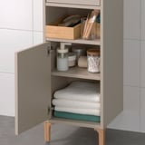 Cabinet with open and hidden storage, ideal for small spaces. Shelves hold towels and bathroom essentials.