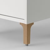 Modern white bathroom cabinet with wooden legs. High-quality materials. Stylish and compact.