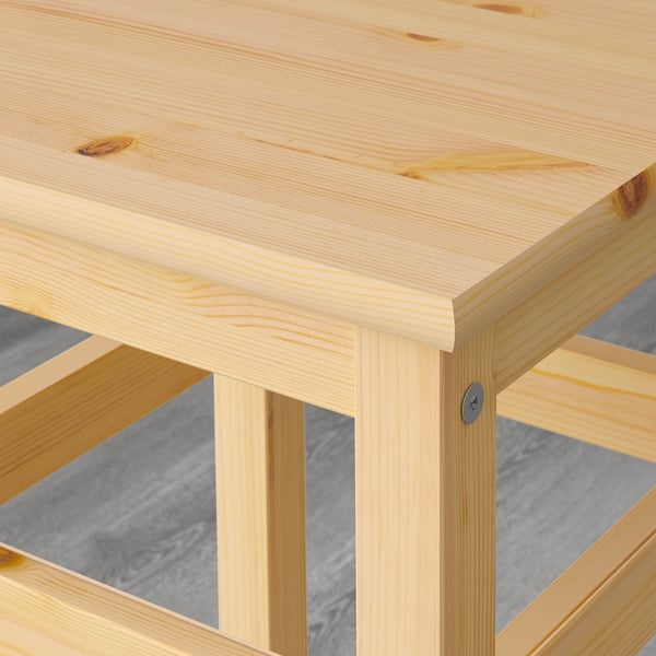 Wooden table corner - smooth, natural finish, showing grain detail.