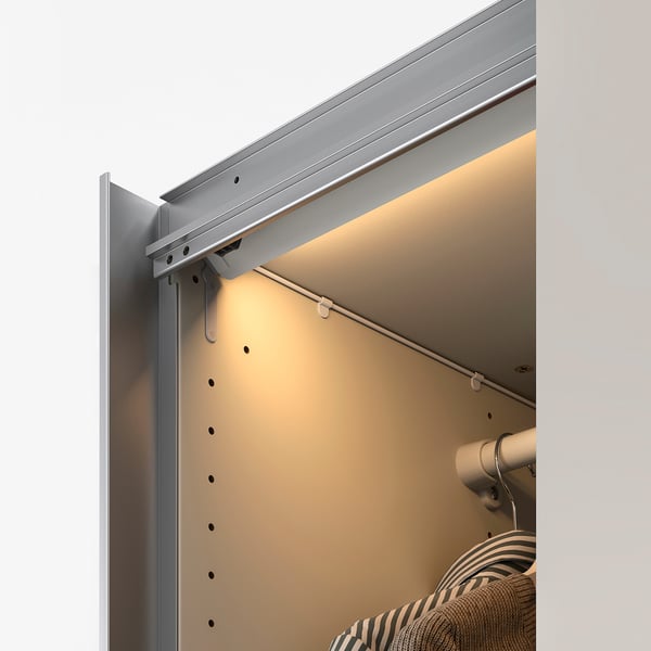 Led lights illuminating wardrobe and shelf.
