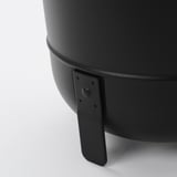 Black round planter with sleek design and sturdy legs