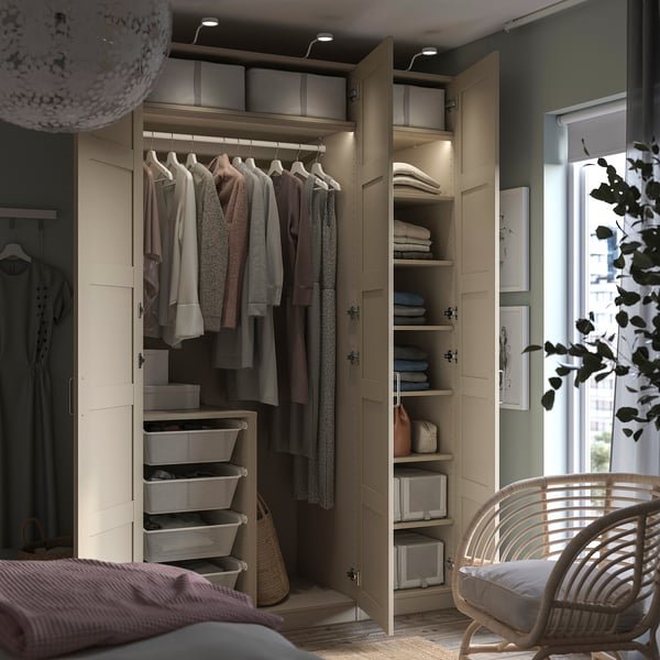 Neat bedroom closet, PAX beige wardrobe with clothes, shelves, baskets, and lights.