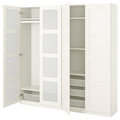 A white ikea PAX wardrobe with mirrored doors and open compartments revealing shelves and a mesh drawer.