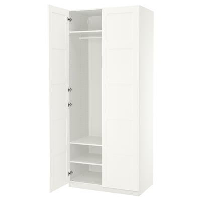 White PAX wardrobe, tall, rectangular with one open door revealing shelves and hanging rod.