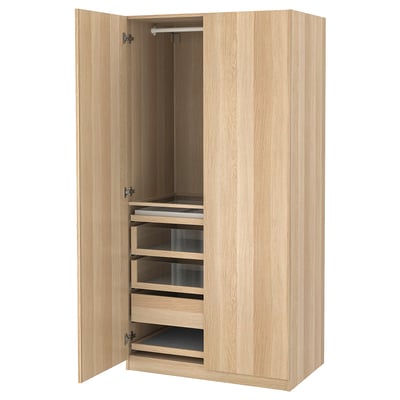 A wooden PAX wardrobe, open. It has multiple shelves and drawers, including glass-fronted ones, set in an oak finish.