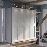 Modern entryway with large white PAX wardrobe, sliding doors, integrated lighting, and wooden accents.