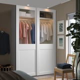 Modern bedroom with PAX wardrobe and clothes beside a window