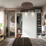 Modern bedroom with PAX wardrobe, lamp, and polka-dot bedspread.