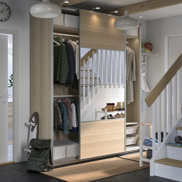 Modern closet with sliding doors, wooden finish, integrated lighting, and mesh storage, ideal for organizing clothes and accessories.