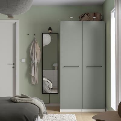 Modern bedroom with grey PAX wardrobe and mirrored doors reflecting the room.
