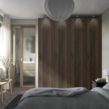 Modern bedroom with PAX wardrobe, soft-close doors, glass-paneled door, rounded ceiling light.