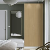 Minimalist bedroom with PAX wardrobe, mirror, and pendant lamp.