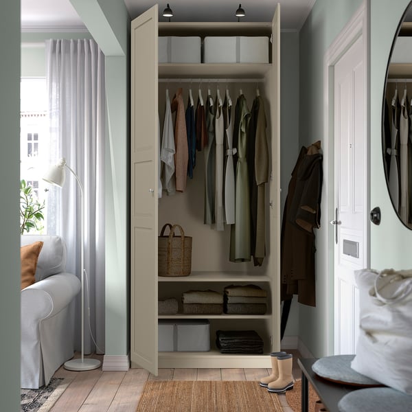 Closed wardrobe with organized clothes, storage baskets, and boots. Light-colored doors and walls.