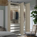 Modern bedroom wardrobe with hangers, drawers, and shelves. Clothes are neatly organized, and led lights illuminate the interior.