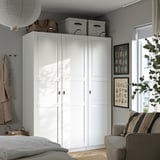 White PAX wardrobe, gray wall, beige sofa, frosted doors, gray boxes, hooks, basket, bright room, window, plant.