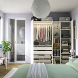 Modern wardrobe with hanging clothes, shelves, and drawers, featuring integrated lighting and a slow-closing door.