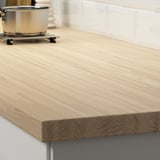 Wooden kitchen countertop with smooth surface and visible grain pattern.