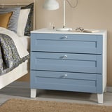 Blue nightstand with lamp beside bed.