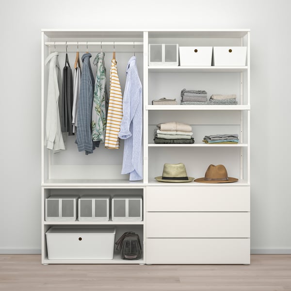 A well-organized closet with hanging shirts, folded clothes on shelves, two hats, and storage containers.