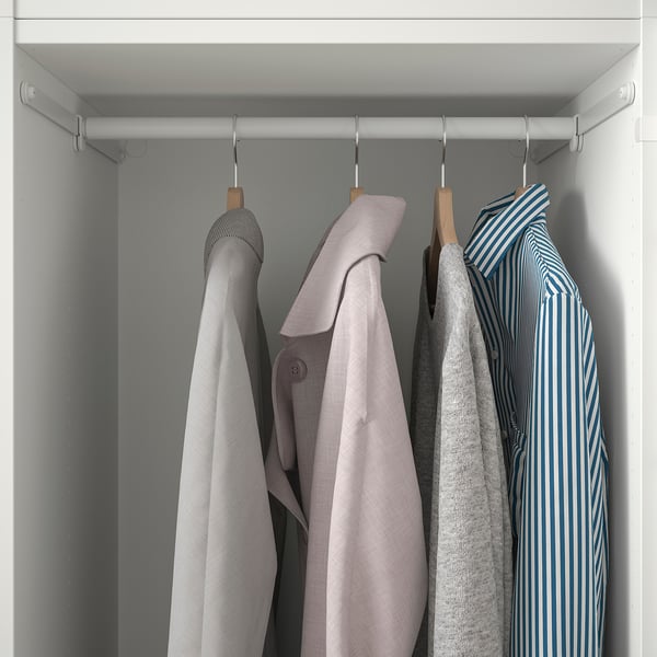 Closet with hanging rods holds several coats neatly on wooden hangers.