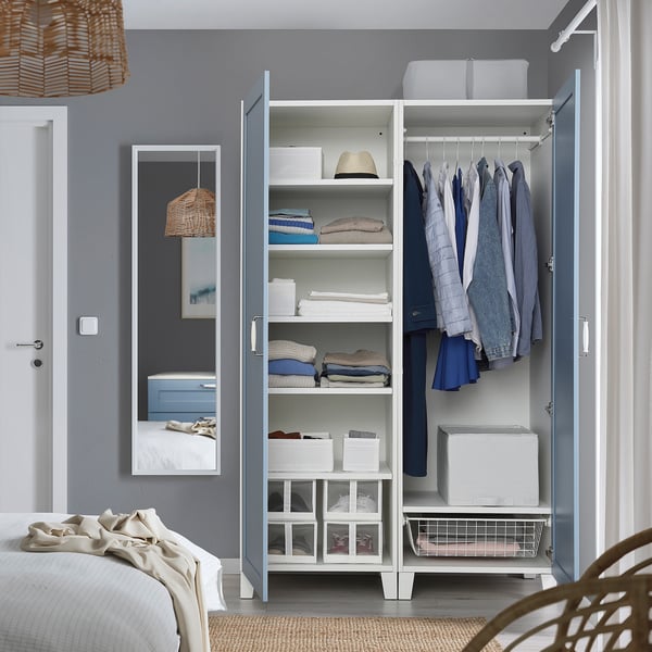 Open wardrobe with clothes hangers, shelves, and storage boxes.