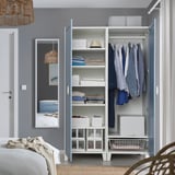 Open wardrobe with clothes hangers, shelves, and storage boxes.