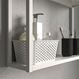 White bathroom shelf with basket holding toiletries and containers.